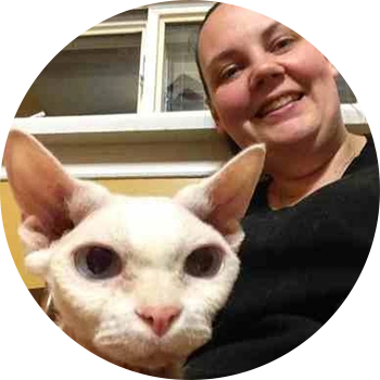 A woman and her cat are smiling for the camera.