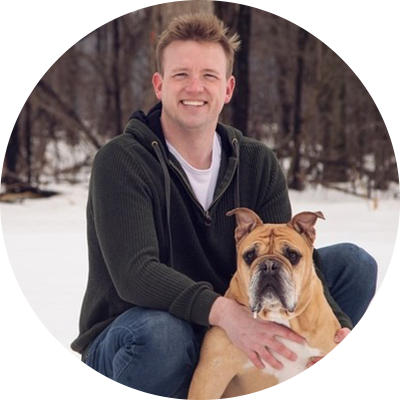 A man holding his dog in the snow.